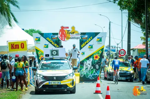 La voiture officielle ouvre la route pendant qu'un concurrent s'élance du Km 0.